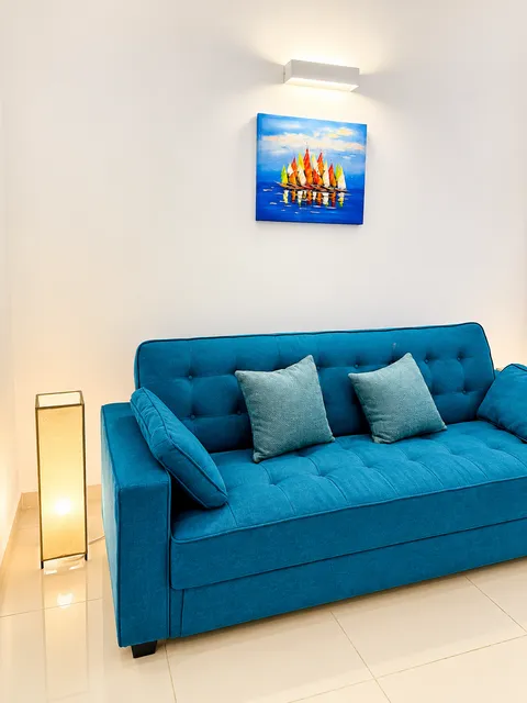 Blue sofa with cushions and a floor lamp